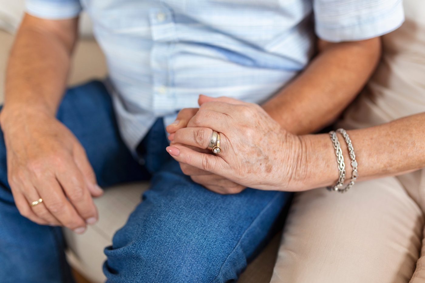 Mains d'un couple âgé portant leurs alliances, après 50 ans de mariage
